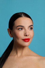 Fototapeta premium Attractive smiling woman against light blue background