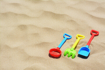 Fototapeta na wymiar Set of colorful beach toys on sand. Space for text