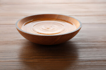 Bowl with pure water on wooden table