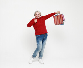 Full length photo of positive cheerful grey white hair elderly woman enjoy leisure time shopping hold bags