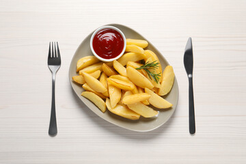 Plate with tasty baked potato wedges, rosemary and sauce on white wooden table, flat lay