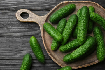 Fresh ripe cucumbers on dark wooden table, flat lay