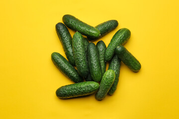 Heap of fresh ripe cucumbers on yellow background, flat lay