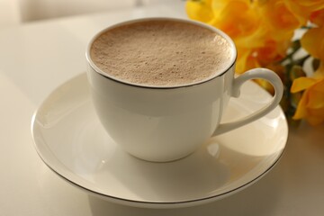 Delicious morning coffee and flowers on white table, closeup