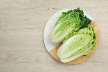 Fresh ripe Chinese cabbages on white wooden table, top view. Space for text