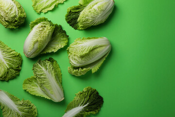 Fresh ripe Chinese cabbages on light green background, flat lay. Space for text