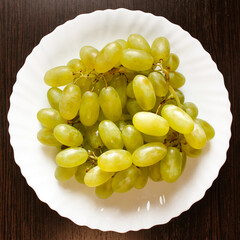 Close-up photo of a bunch of grapes on a white plate.