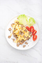 Scrambled eggs recipe with black truffles, bread tomatoes , white background. Black truffles gourmet brunch, breakfast. Healthy recipe of Piedmont, Italy, Spain and France, top view