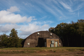cold war bunker for military fighter jets under a blue sky in fall.