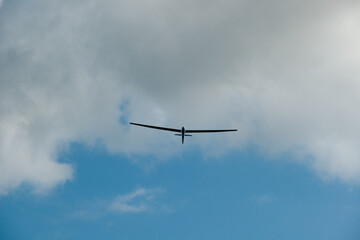 a glider or sailplane flying over an airfield.