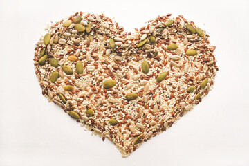 An object in the shape of a heart from a scattering of various seeds and grains.