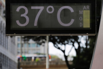 Street digital thermometer displays a temperature of 37 degrees celsius with a moderate air quality during an extreme heat wave in Sao Paulo, Brazil. - obrazy, fototapety, plakaty