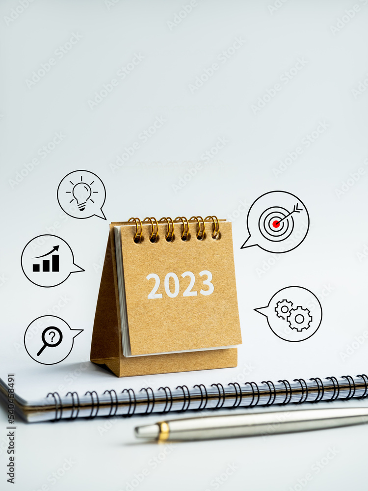 Poster 2023 numbers year on small beige desk calendar cover on notepad with pen and business process and su