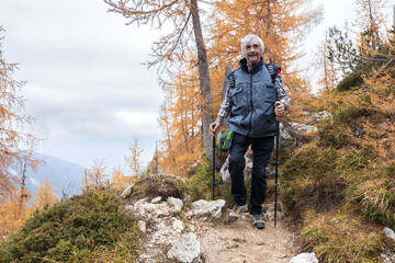 Front View of Caucasian Senior Man Descending Hike a Slope on Alpine Mountain Trail