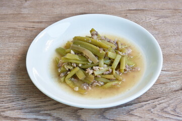 fried slice lotus stems with chop pork in soy sauce on plate