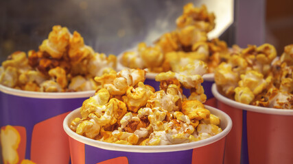 Popcorn in paper cups is served on a street stall. Close-up