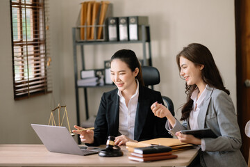 Asian business team and lawyers discussing contract papers sitting at the table. Concepts of law,...