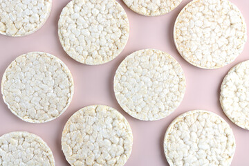 Pattern of rice crackers on a pink background. Low calorie whole grain rice crackers.