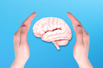 Human brain and hands isolated on blue background, mental health and problems with memory