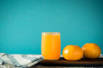 glass of fresh orange juice with fresh fruits on wooden table, high Vitamin C, orange drink