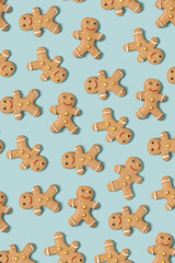 Christmas gingerbread man cookies arranged on a pastel blue background. Traditional Xmas background.