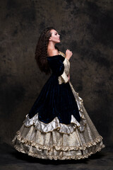 Beautiful woman in renaissance royal dress on abstract dark background