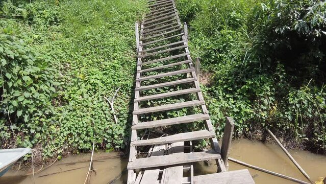 Handheld 4K View of the old wooden stair which was wrecked stands firmly on the ground from the floating river deck