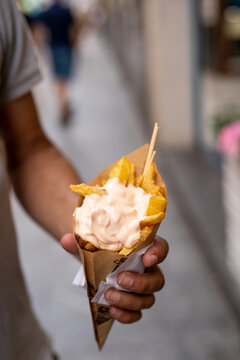 Man Holding A Bunch Of Fried Chips In The Street