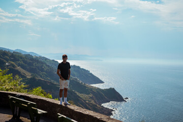 Fototapeta premium Young man in front of the aerial landscape view of San Sebastian, spain