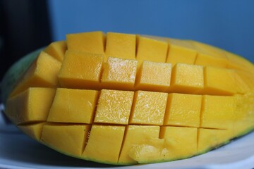 sliced ​​fresh mango in the shape of a cube on a plate