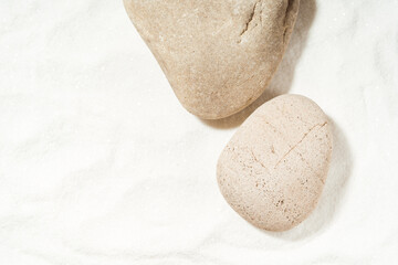 Mockup scene with sea stones on a white sand background. Natural pedestal or stage for cosmetic...