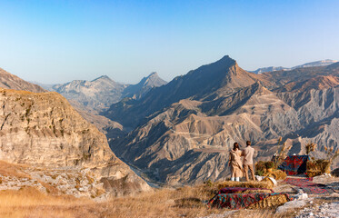Couple of young hikers admiring the autumn mountains near the village of Golotl in the Khunzakh...