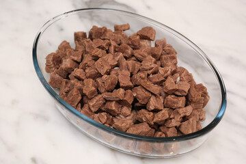Roasted meat in glass bowl on white marble background