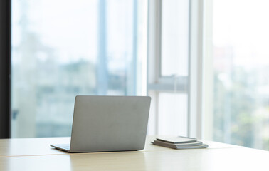 Laptop on a desk in an open financial office.