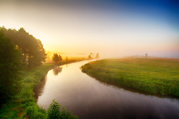 Landscape sunset in Narew river valley, Poland Europe, foggy misty meadows with trees, spring time	