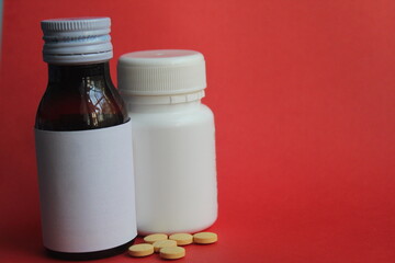 medicine tablets and medicine syrup on a red background