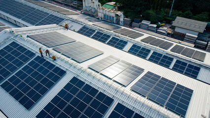 Fototapeta Fly over unidentified Engineering set up a Solar cell on the roof of a large industrial factory. Solar roofs are generating renewable energy for the industry. obraz