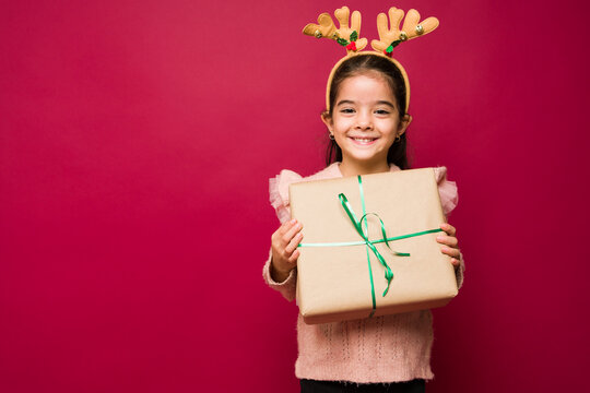 Cheerful kid feeling happy with her christmas gift