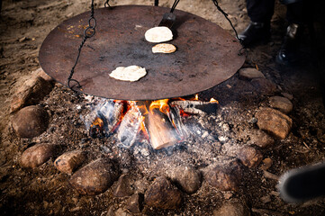 Breads from dough on an iron plate over the fire