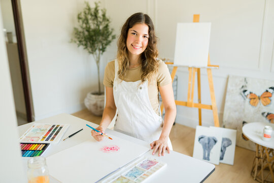 Attractive cheerful woman enjoying her painting hobby