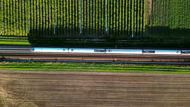 Luftaufnahme einer zweigleisigen Eisenbahn auf dem Land mit vorbeifahrendem Hochgeschwindigkeitszug
