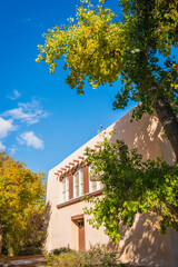 Fototapeta na wymiar Autumn Southwestern landscape and vibrant foliage with partial view of Adobe house in Albuquerque, New Mexico, USA