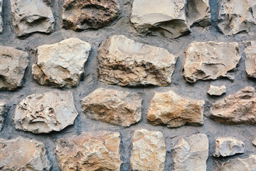 text background Rough stone wall as creative background texture. Natural stones masonry with uneven seams. Stone wall background