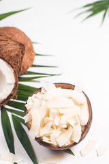 Coconut chips with coconut and green leaves on a white background. Isolated concept.