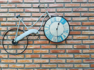 Fototapeta na wymiar classic bike parked by brick wall, with clock in wheel