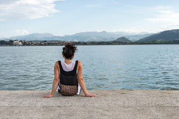 Fototapeta na wymiar Woman sits on Santander Promenade