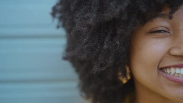 Cinematic video of a self confident young woman spending time in a modern city. Millennial girl with afro hairstyle lifestyle moments.
