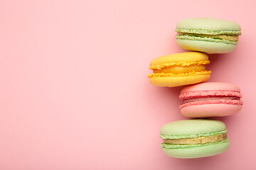 Fototapeta na wymiar Colorful macarons cakes on pink background. Small French cakes.