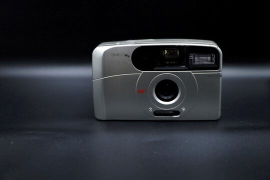A point and shoot vintage film camera isolated on a black background.