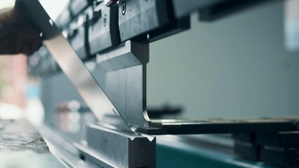 Press operator bending sheet metal. Close up.